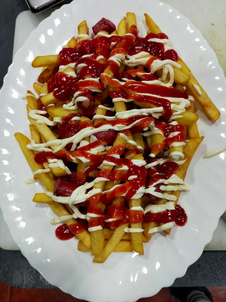abundante salchipapa bañada con ketchup y mayonesa.